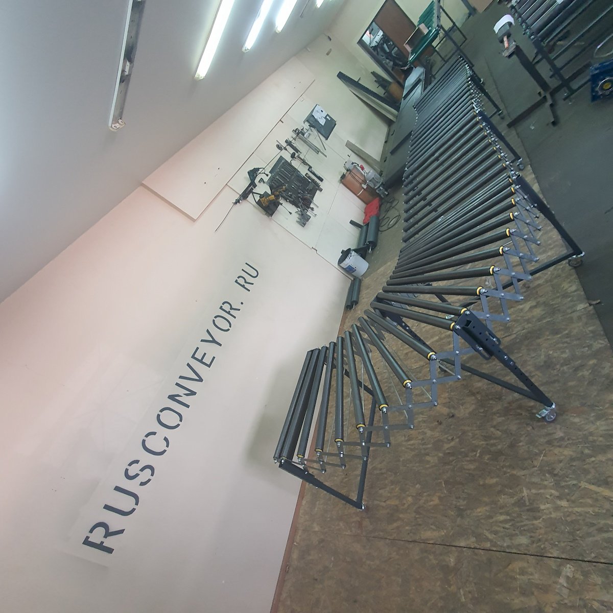 Изогнутый контур стального раздвижного конвейера РР на колесных опорах с роликами шагом до 150 мм