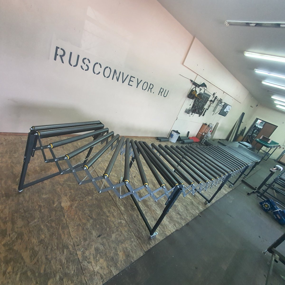 Шестисекционный роликовый конвейер РР выстроенный в виде S-образной линии на бетонном полу цеха